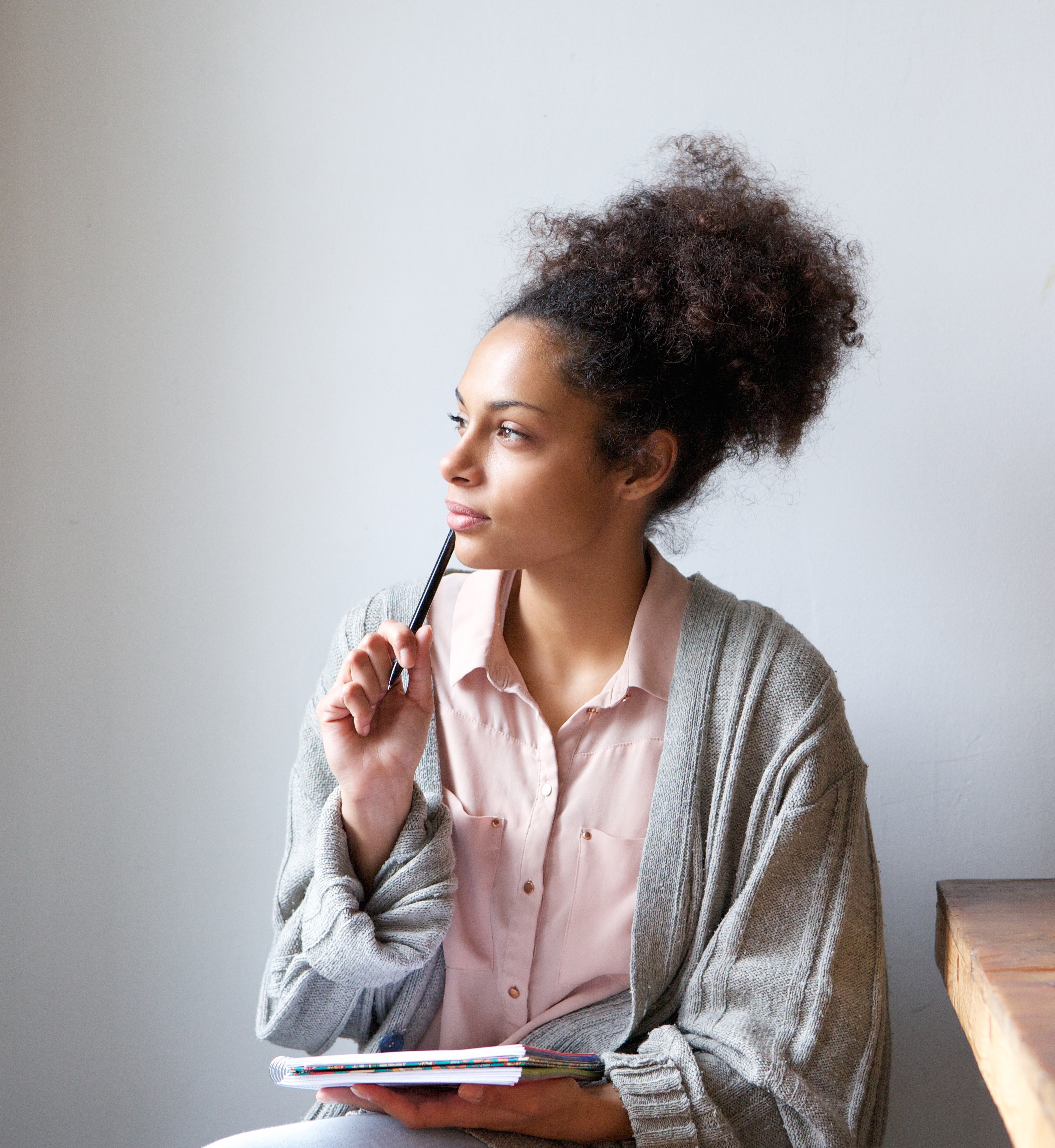 Portrait of a young woman sitting at home with pen and paper